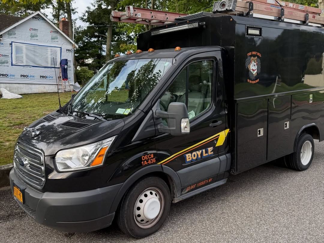 A large black dumpster with the word Boyle on it