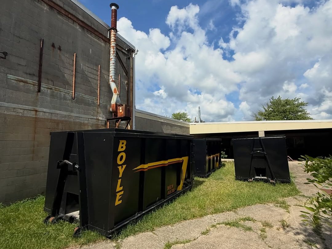 Row of large black dumpsters