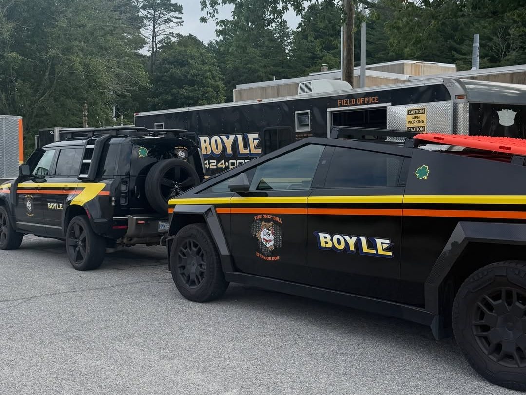 Two black police cars with yellow markings