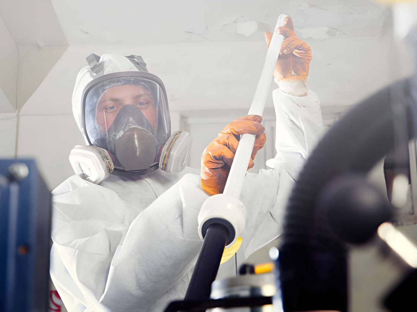 a person in a hazmat suit, likely working with asbestos